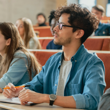 Students seated in a lecture hall, engaged in a lesson from the instructor.